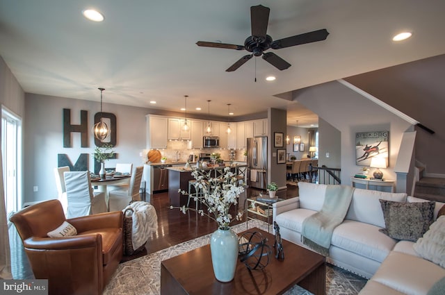 living room with ceiling fan, sink, and dark hardwood / wood-style flooring