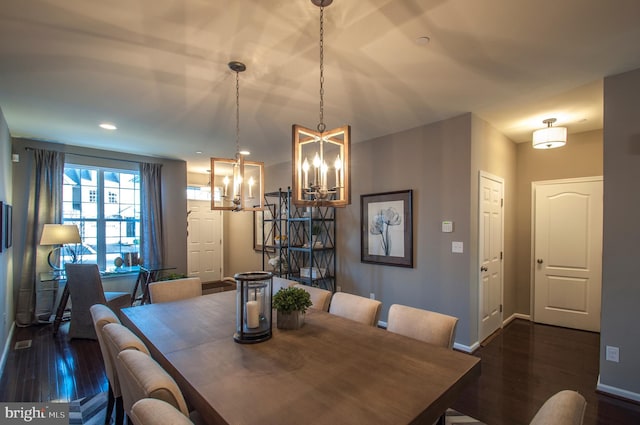 dining space with dark wood-type flooring and a chandelier