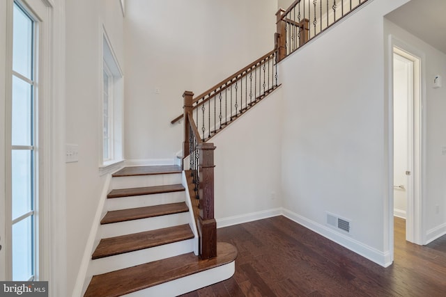 stairs with dark hardwood / wood-style flooring