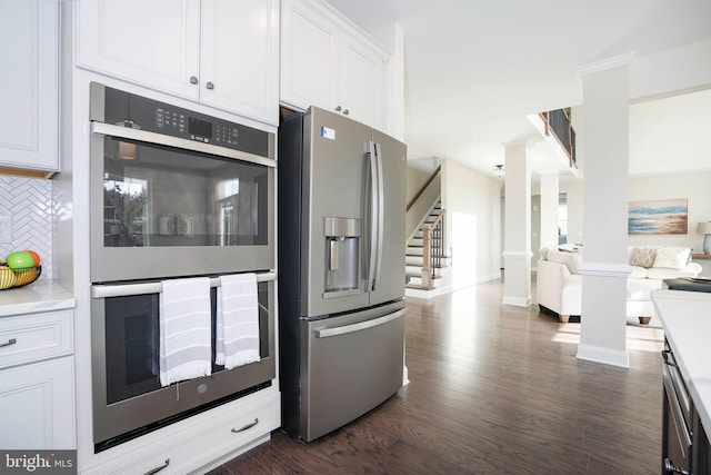 kitchen featuring white cabinetry, dark wood-type flooring, appliances with stainless steel finishes, and tasteful backsplash