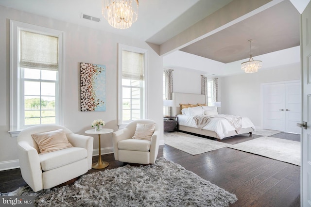 bedroom with beamed ceiling, a chandelier, and dark hardwood / wood-style floors