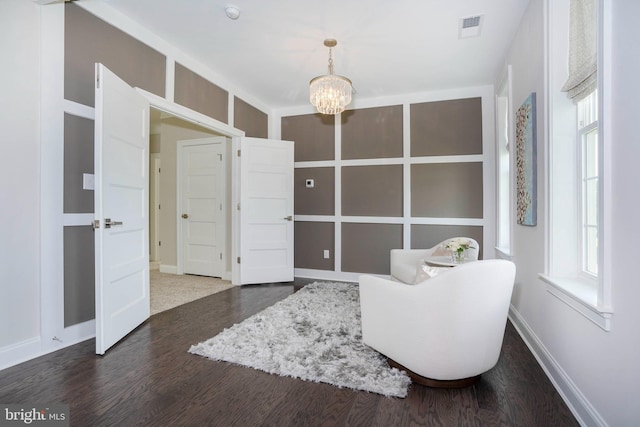 living area featuring dark hardwood / wood-style floors and a notable chandelier