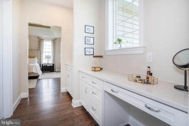 bar featuring white cabinets, light stone countertops, and dark wood-type flooring