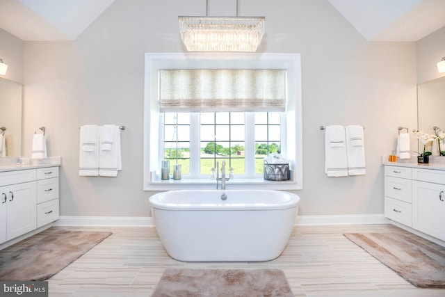 bathroom featuring vanity, a tub, and lofted ceiling