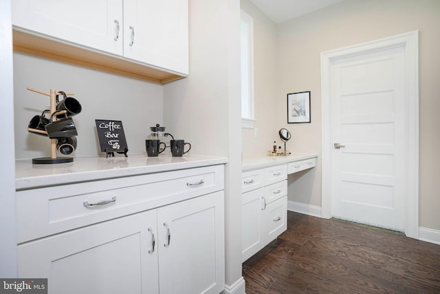 bar with white cabinets and dark wood-type flooring