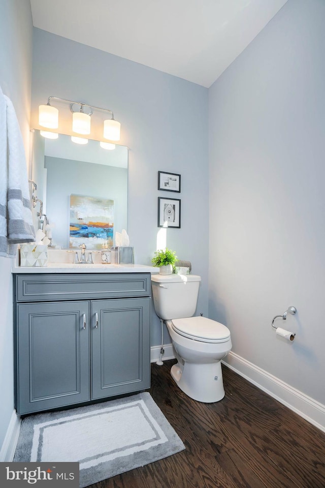 bathroom with vanity, toilet, and wood-type flooring