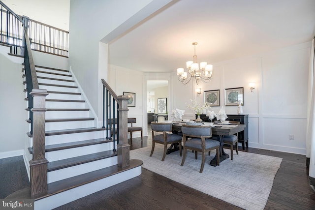 dining area with ornamental molding, an inviting chandelier, and dark wood-type flooring