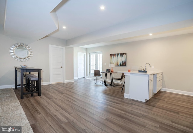 interior space with dark hardwood / wood-style flooring, white cabinetry, and sink