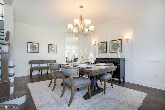 dining room featuring a chandelier, crown molding, and dark wood-type flooring