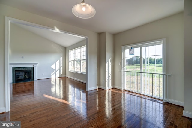 unfurnished living room featuring dark hardwood / wood-style floors and vaulted ceiling