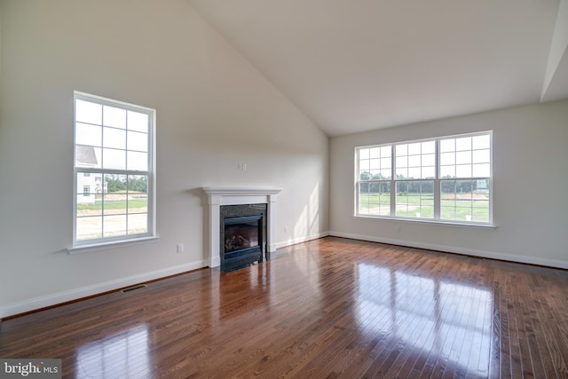 unfurnished living room featuring high vaulted ceiling and dark hardwood / wood-style flooring