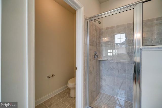 bathroom featuring an enclosed shower, toilet, and tile floors