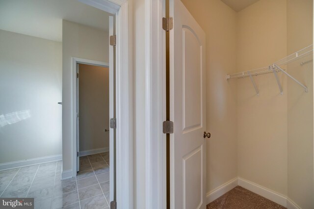 spacious closet with light tile flooring