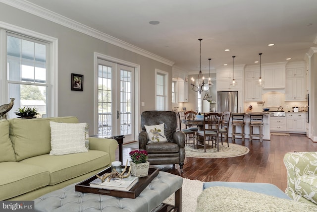 living room with a chandelier, french doors, dark hardwood / wood-style flooring, and crown molding