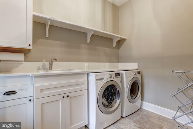 laundry area featuring cabinets, separate washer and dryer, sink, and light tile patterned floors