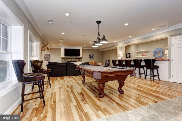 game room with a fireplace, crown molding, light hardwood / wood-style flooring, and pool table