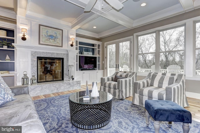 living room featuring a fireplace, hardwood / wood-style floors, ceiling fan, and built in shelves