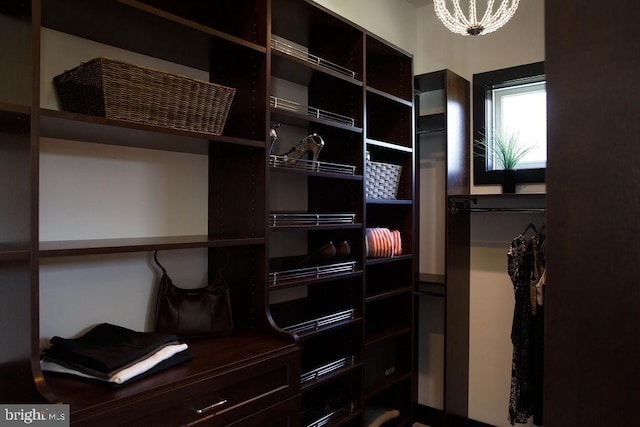 spacious closet featuring a notable chandelier