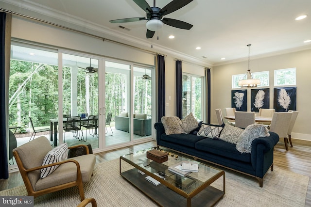 living room featuring crown molding, ceiling fan, and light hardwood / wood-style flooring