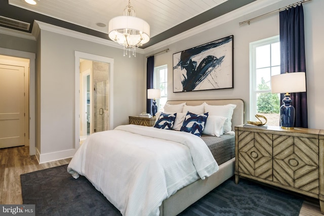 bedroom featuring ornamental molding, dark hardwood / wood-style floors, and a chandelier