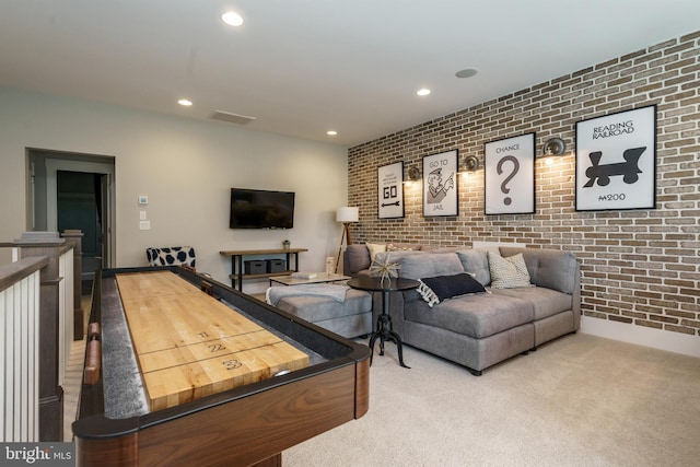 carpeted living room with brick wall