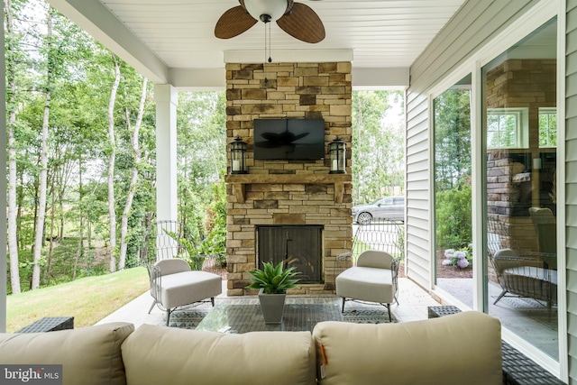 view of terrace with an outdoor living space with a fireplace and ceiling fan