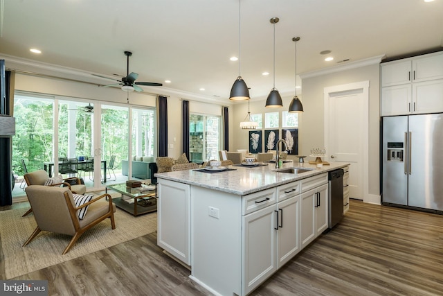 kitchen featuring white cabinets, a center island with sink, and stainless steel appliances