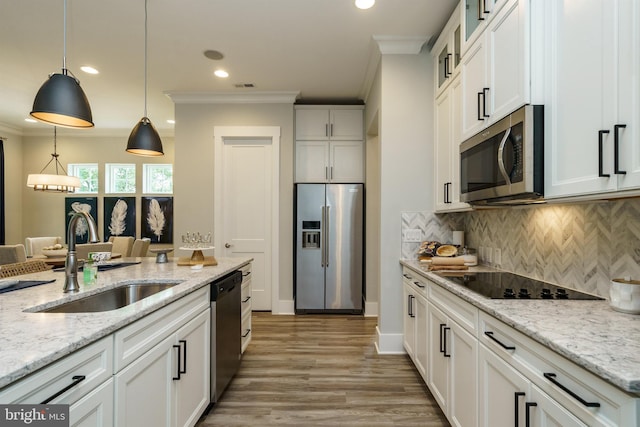 kitchen featuring pendant lighting, stainless steel appliances, white cabinets, backsplash, and light wood-type flooring