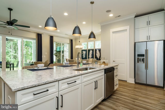 kitchen featuring ceiling fan, appliances with stainless steel finishes, sink, white cabinets, and pendant lighting