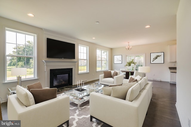 living room featuring a healthy amount of sunlight, dark hardwood / wood-style floors, and a notable chandelier