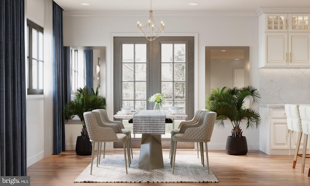 dining space with light hardwood / wood-style flooring, a chandelier, and ornamental molding