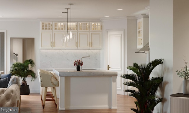 kitchen featuring light hardwood / wood-style floors, crown molding, sink, and hanging light fixtures