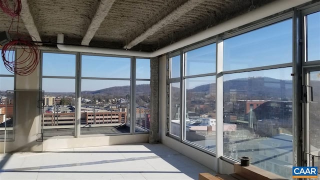 unfurnished sunroom featuring a mountain view