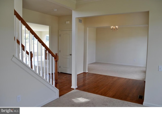 carpeted empty room with a chandelier