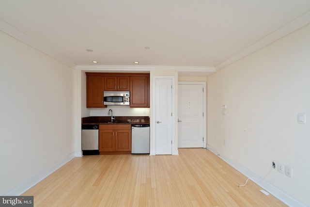 kitchen featuring crown molding, sink, appliances with stainless steel finishes, and light wood-type flooring