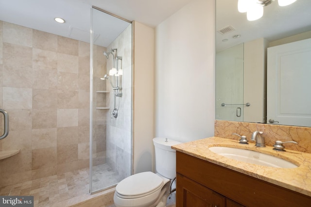 bathroom featuring walk in shower, toilet, and vanity