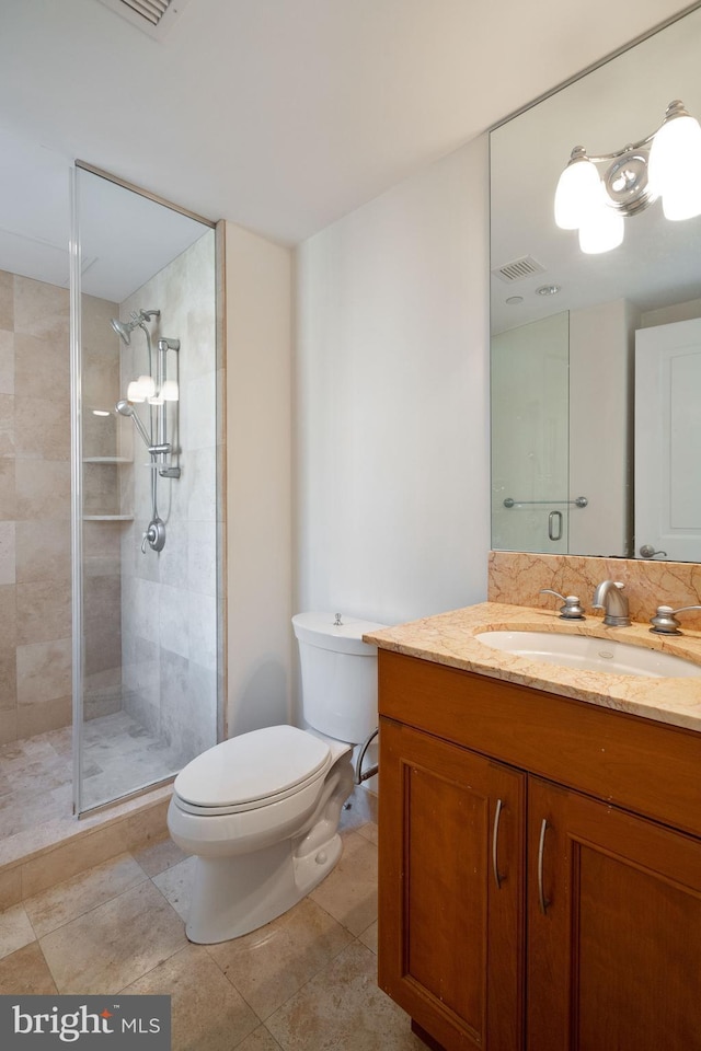 bathroom featuring vanity, tile floors, toilet, and walk in shower