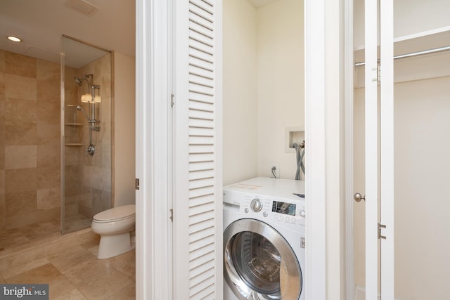 clothes washing area featuring washer / clothes dryer and light tile floors