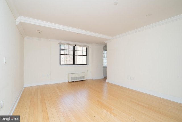 empty room featuring radiator, ornamental molding, and light wood-type flooring