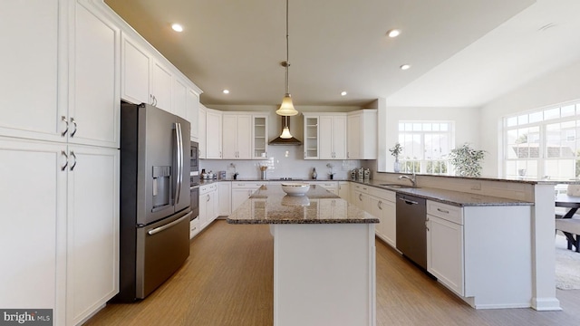 kitchen with white cabinets, a center island, a kitchen bar, and stainless steel appliances