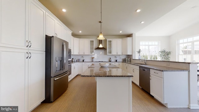 kitchen featuring a center island, white cabinetry, light wood-type flooring, and stainless steel appliances