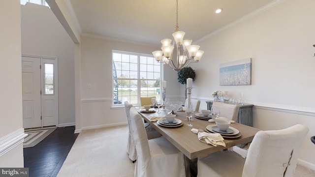 dining area featuring a notable chandelier, ornamental molding, and dark hardwood / wood-style floors