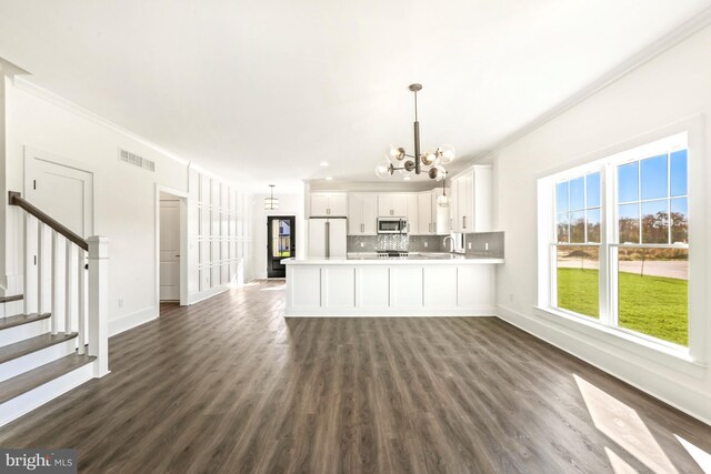 interior space with white cabinets, hanging light fixtures, dark wood-type flooring, and white refrigerator