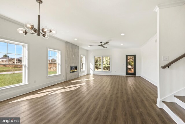 unfurnished living room with ornamental molding, ceiling fan with notable chandelier, dark hardwood / wood-style floors, and a fireplace