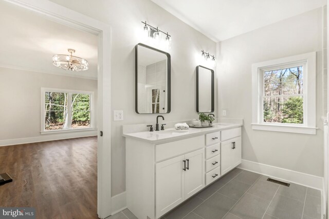 bathroom with a chandelier, a healthy amount of sunlight, double sink, and large vanity