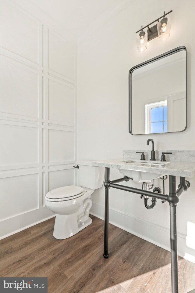 bathroom featuring toilet, hardwood / wood-style floors, and sink