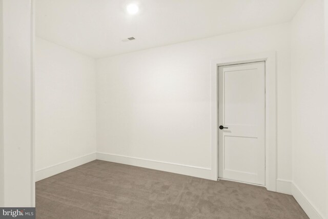 unfurnished room with dark colored carpet