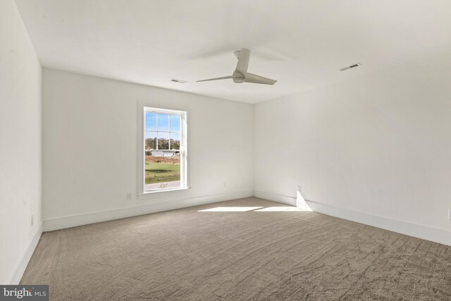 spare room featuring light carpet and ceiling fan