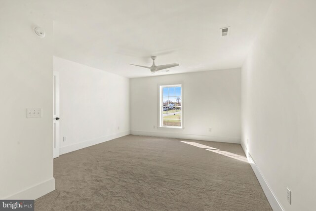 empty room featuring carpet floors and ceiling fan