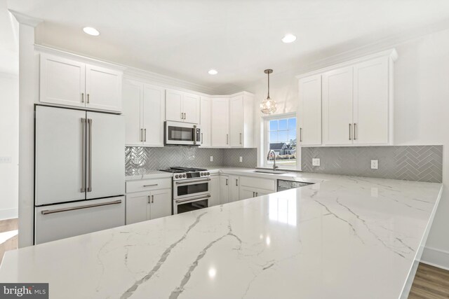 kitchen featuring built in refrigerator, white cabinets, wood-type flooring, range with two ovens, and sink